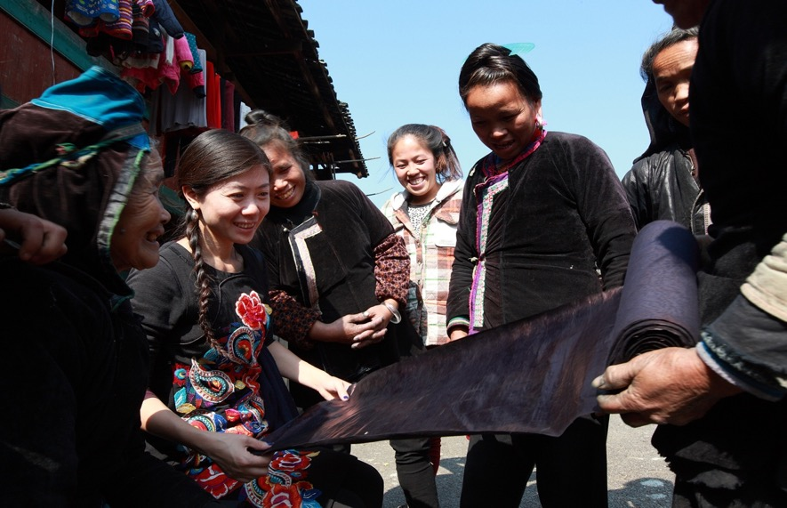 Bampo design team happily unrolling bright Dong cloth in a Guizhou Dong village in 2013