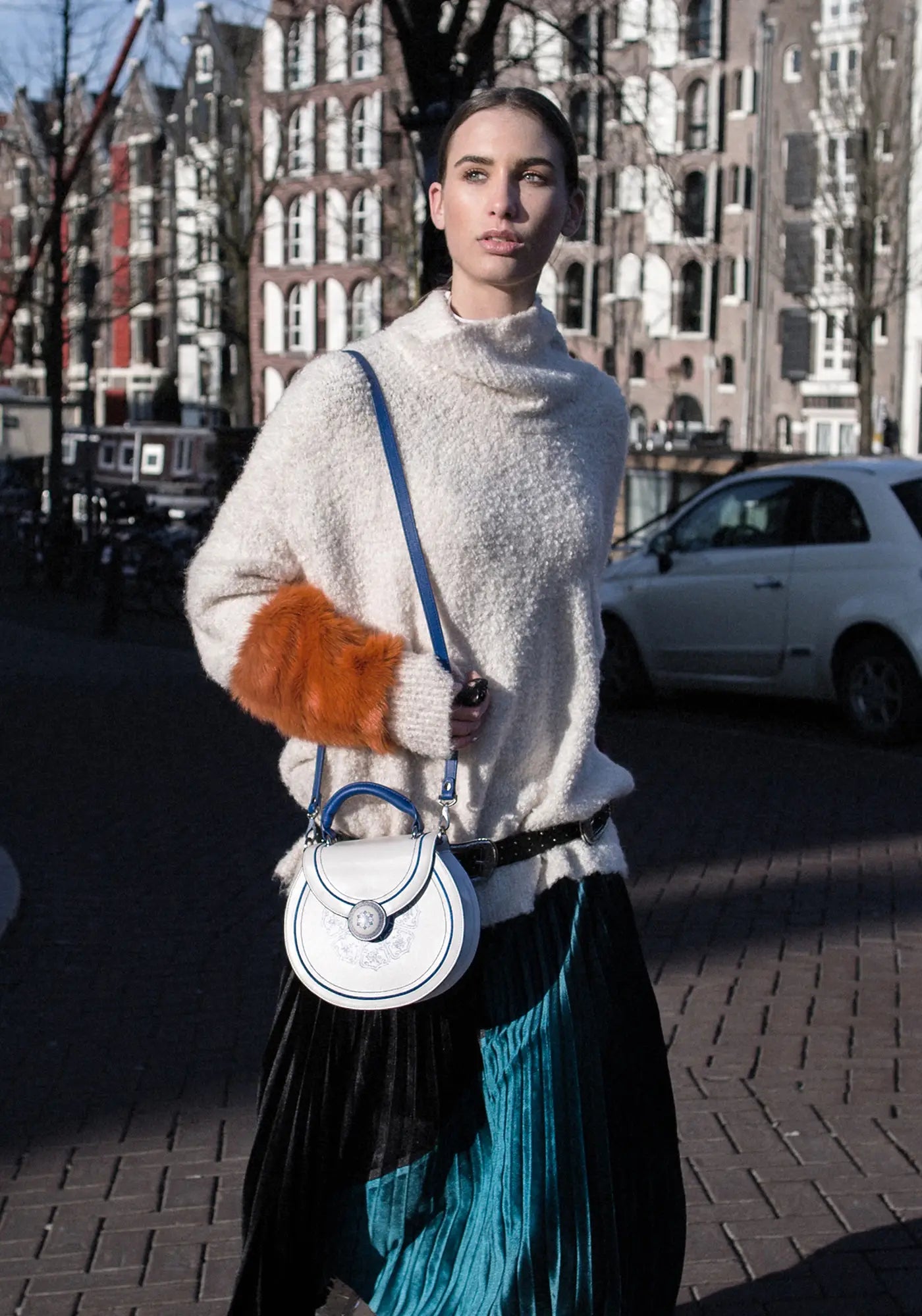 A woman carrying the Bampo Blue and White Porcelain Handbag on one shoulder while walking