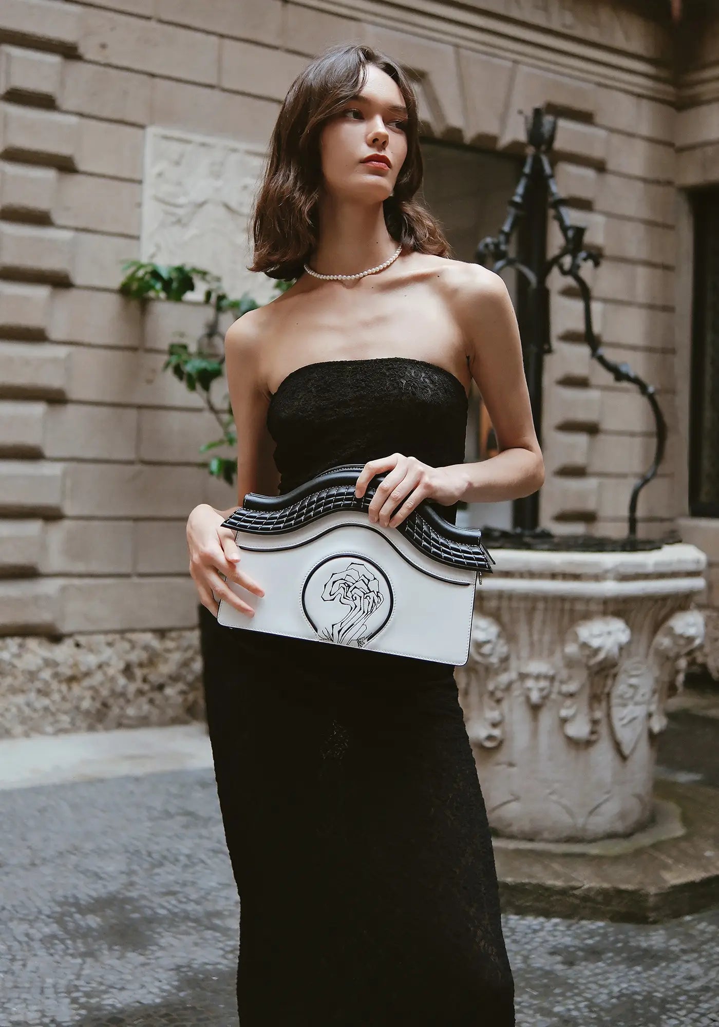 A woman holding the Bampo Garden of Pleasance Handbag Deluxe Edition